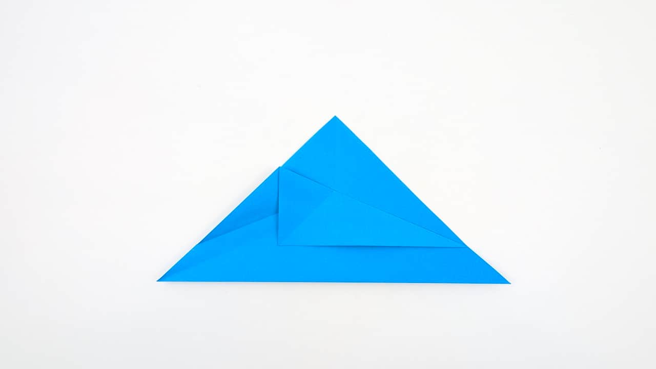 Lift the bottom point of the front layer up while opening the two flaps — squash into a petal fold.